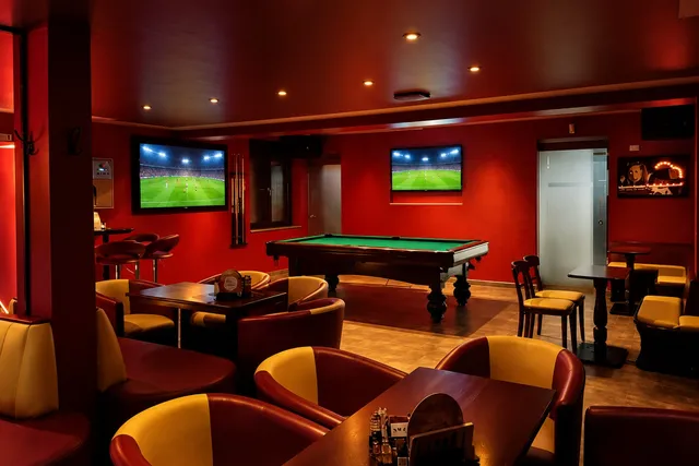 Sportsbar mit TVs, Lounge-Sesseln und Billardtisch